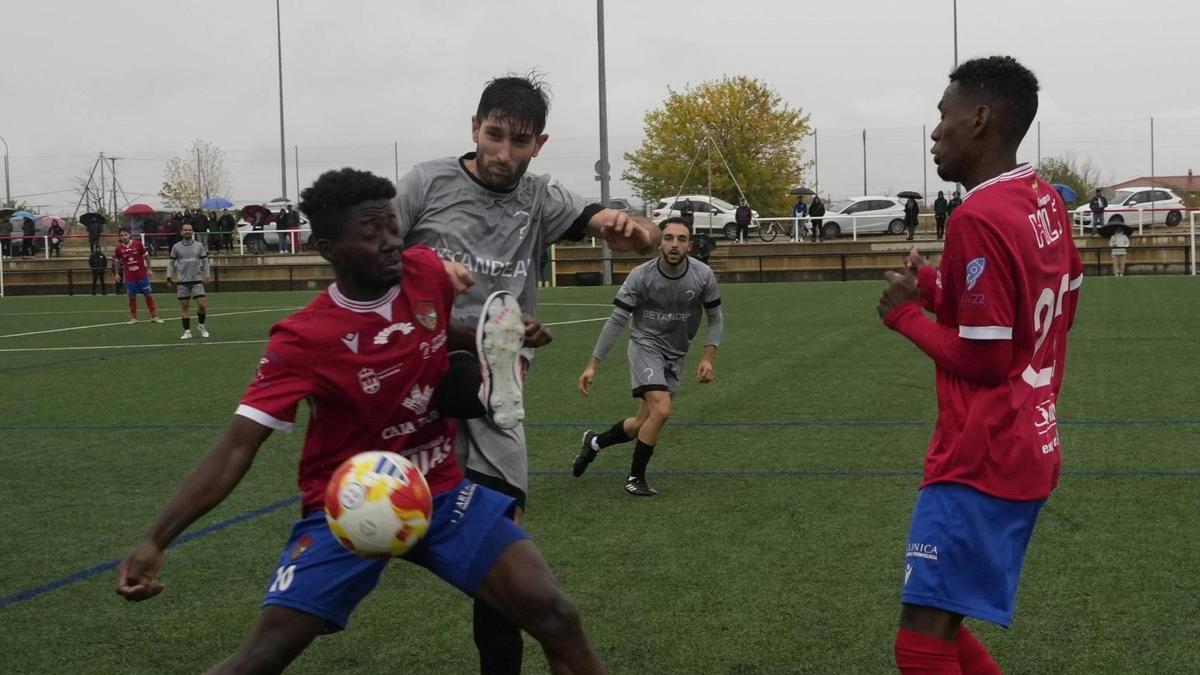 Noel trata de hacerse con el balón ante dos jugadores del CD Benavente en el duelo jugado entre ambos equipos en Zamora.