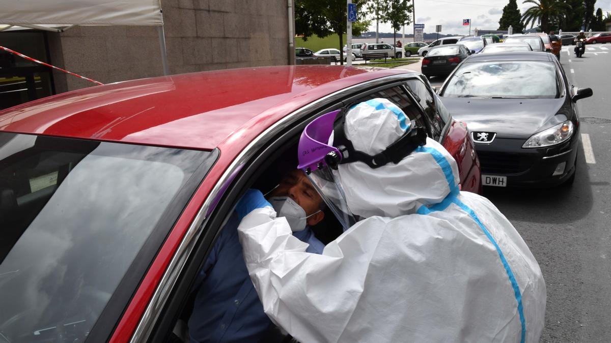 Un sanitario realiza una PCR a una persona en el Covidauto de O Ventorrillo.