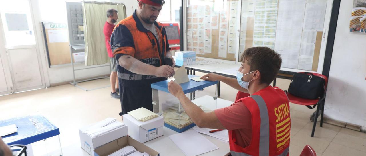 Un trabajador de Avanza, este miércoles, depositando su voto en una de las urnas habilitadas en las cocheras de la empresa para decidir sobre el futuro de los paros.  | ÁNGEL DE CASTRO