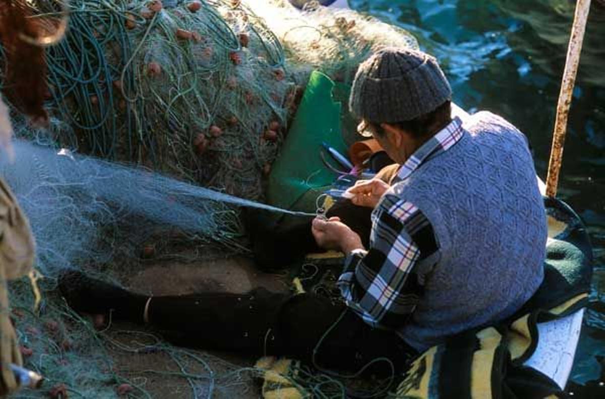 Pescador reparando una red de pesca