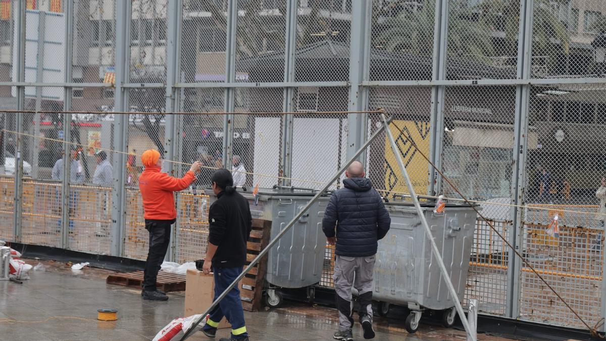 Preparativos de la mascletà de hoy en la plaza del Ayuntamiento con la mirada puesta en el cielo por las lluvias