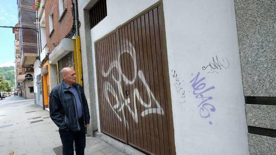 Manuel Prado, junto a una pintada en la puerta de una cochera en la calle La Vega.