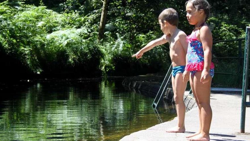 Dos niños en la playa fluvial de A Calzada. // S.A.