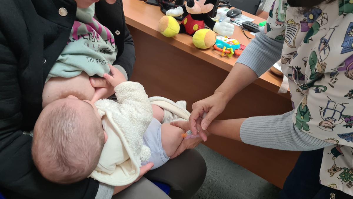 Una enfermera administra la vacuna de la tosferina a un bebé.