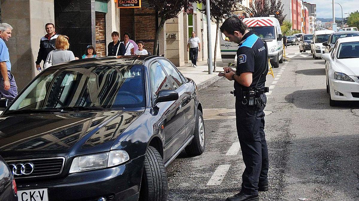 Un agente de Policía Local de Pontevedra multa a un vehículo, en una imagen de archivo. |   // R.V.