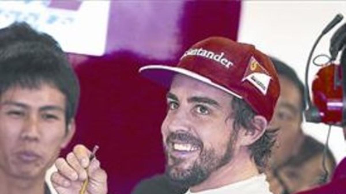 Fernando Alonso se come unas uvas en el taller de Ferrari, ayer, en Suzuka.