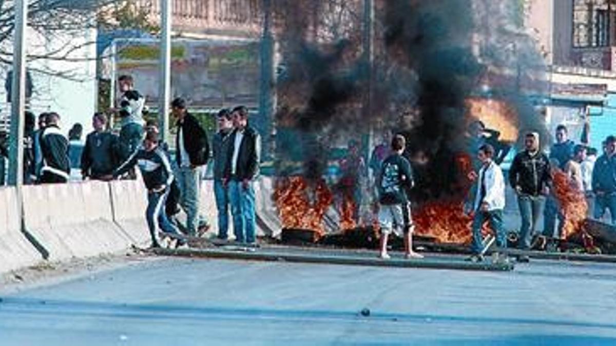 Jóvenes manifestantes levantan una barricada con neumáticos quemados en la ciudad de Constantine, en el este de Argelia.