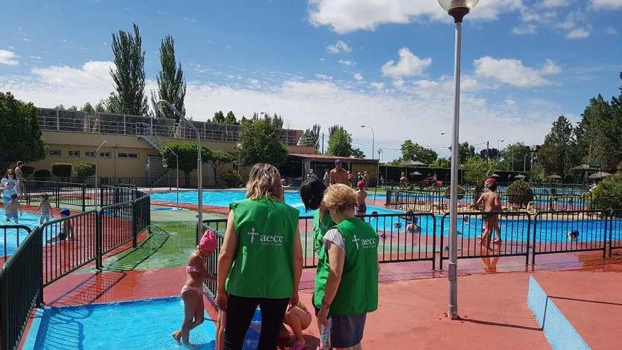 Voluntarios de la AECC en las piscinas municipales ayer por la mañana.