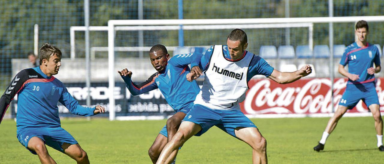 Cervero protege el balón presionado por Omgba ante la mirada de Iñaki Domínguez.