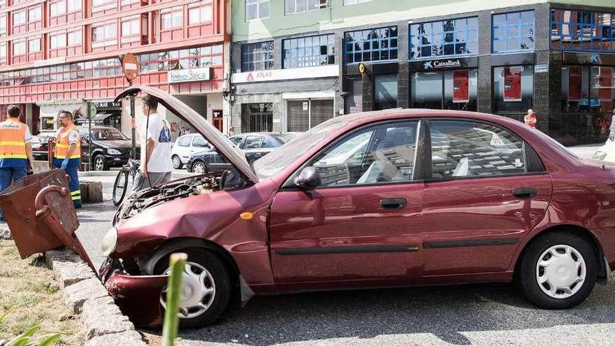 El vehículo accidentado, sobre una acera de la plaza de A Palloza.