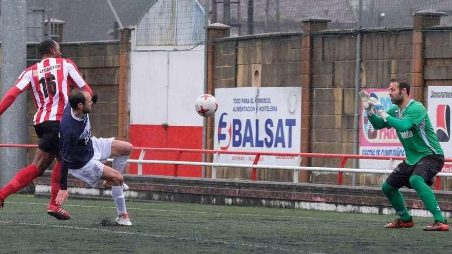 El jugador de L&#039;Entregu Kayce, a la izquierda, trata de superar al portero Davo con la oposición de Guaya, ayer, en el Nuevo Nalón.