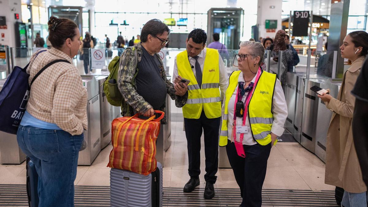 Pasajeros consultan a los informadores de Sants Estació en Barcelona ante el caos de Rodalies.