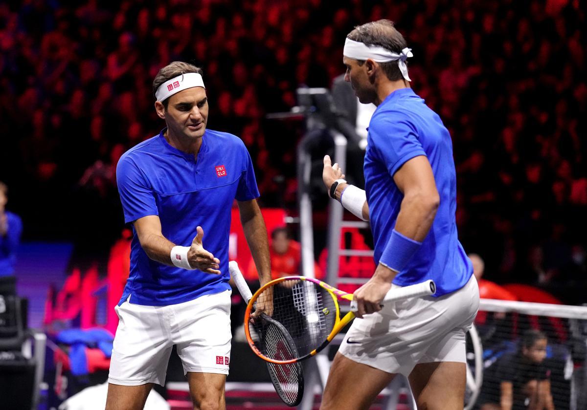 Roger Federer choca con Rafa Nadal durante su partido de dobles de la Copa Laver 2022