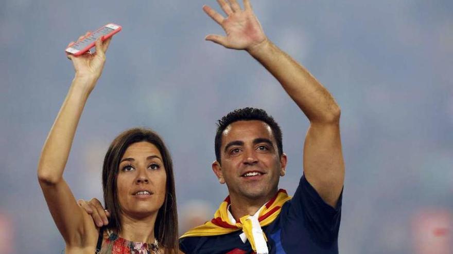 Xavi y su mujer, Nuria Cunillera, saludan a los aficionados en la despedida del capitán azulgrana. // Reuters