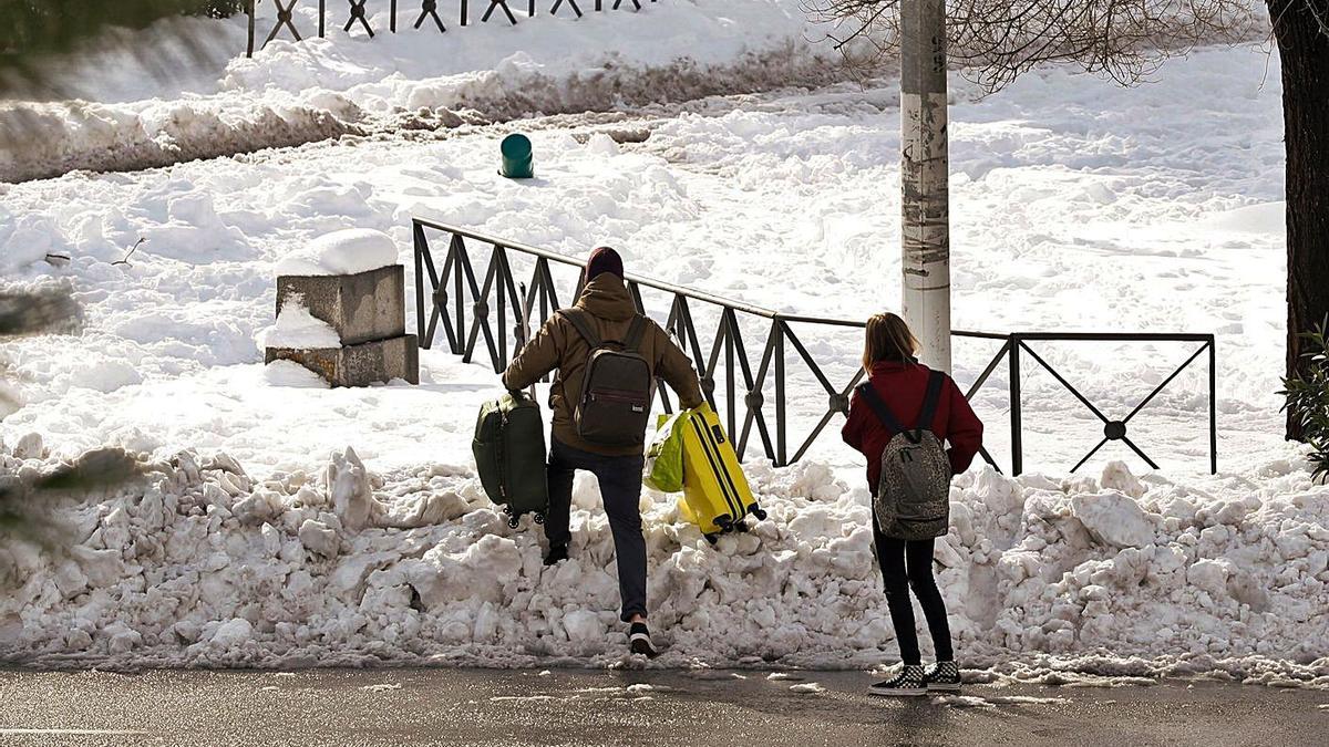 Dos personas avanzan entre la nieve en Madrid, ayer, tras el paso del temporal Filomena.   | // EFE