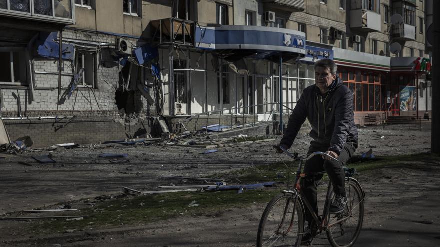 Un hombre en bicicleta cerca de un edificio dañado por los ataques de Rusia contra Severodonetsk.