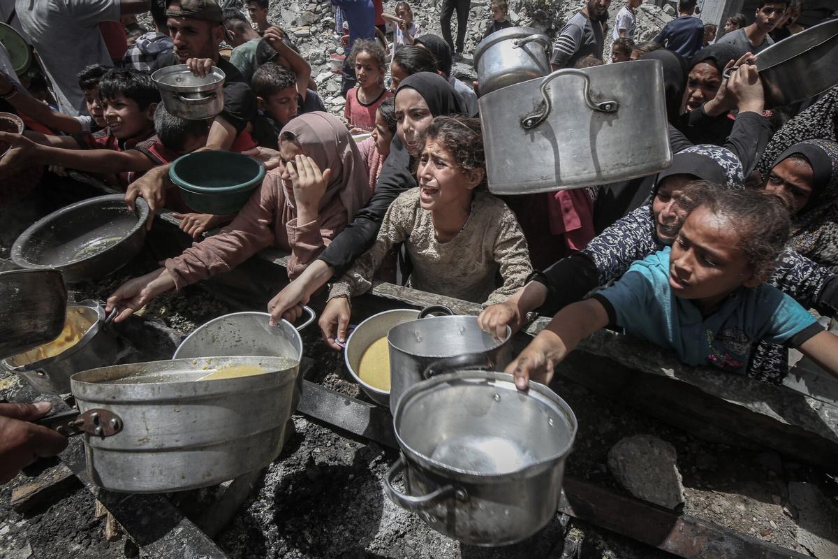 Desplazados palestinos tratan de conseguir comida en una cocina comunitaria de Yabalia, en el norte de Gaza.