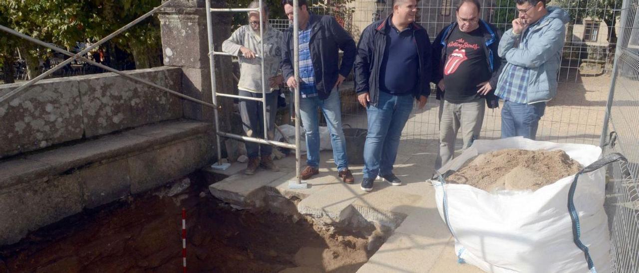 Técnicos y responsables municipales, ayer, junto al sondeo abierto en el atrio de San Benito. | Noé Parga