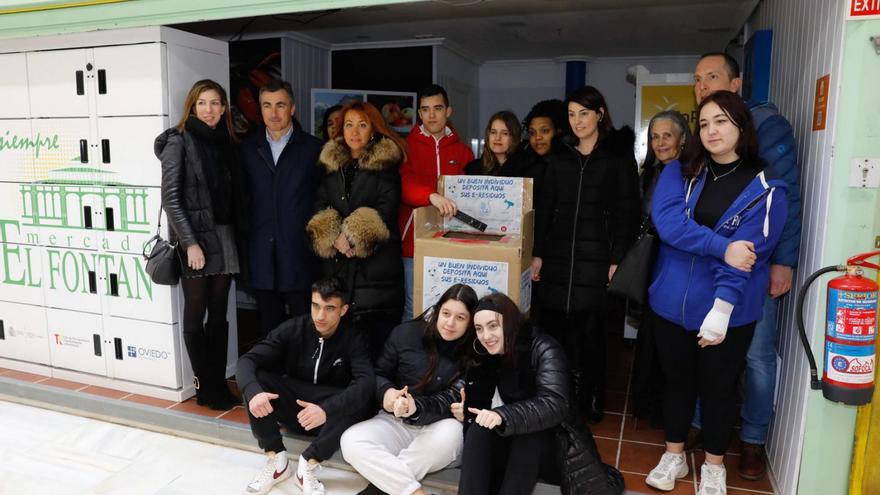 Alumnos, profesores y los representantes del mercado del Fontán, la asociación de comerciantes y el Ayuntamiento, junto al contenedor para los residuos electrónicos.