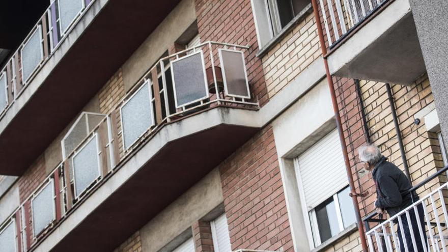 Un veí observa des del seu balcó l&#039;exterior de l&#039;edifici incendiat