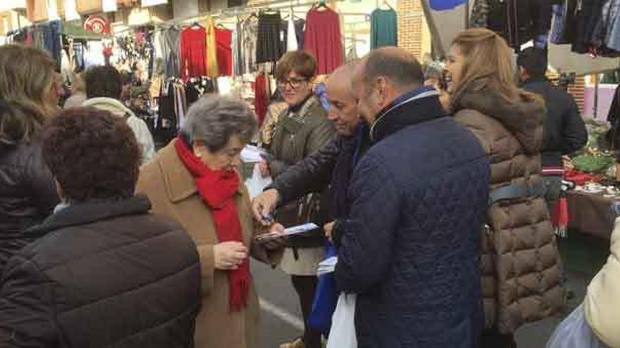 Candidatos del PP repartiendo programas en el mercadillo