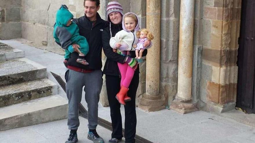 La familia de peregrinos de Alaska posa junto al Santiago peregrino en la iglesia de Santa Marta de Tera.