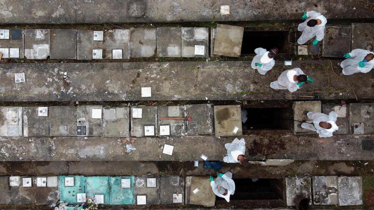 Los empleados del cementerio de Nova Cachoeirinha, el segundo más grande de Sao Paulo (Brasil), retiran los huesos de las tumbas antiguas para hacer sitio a los nuevos muertos por la covid-19.