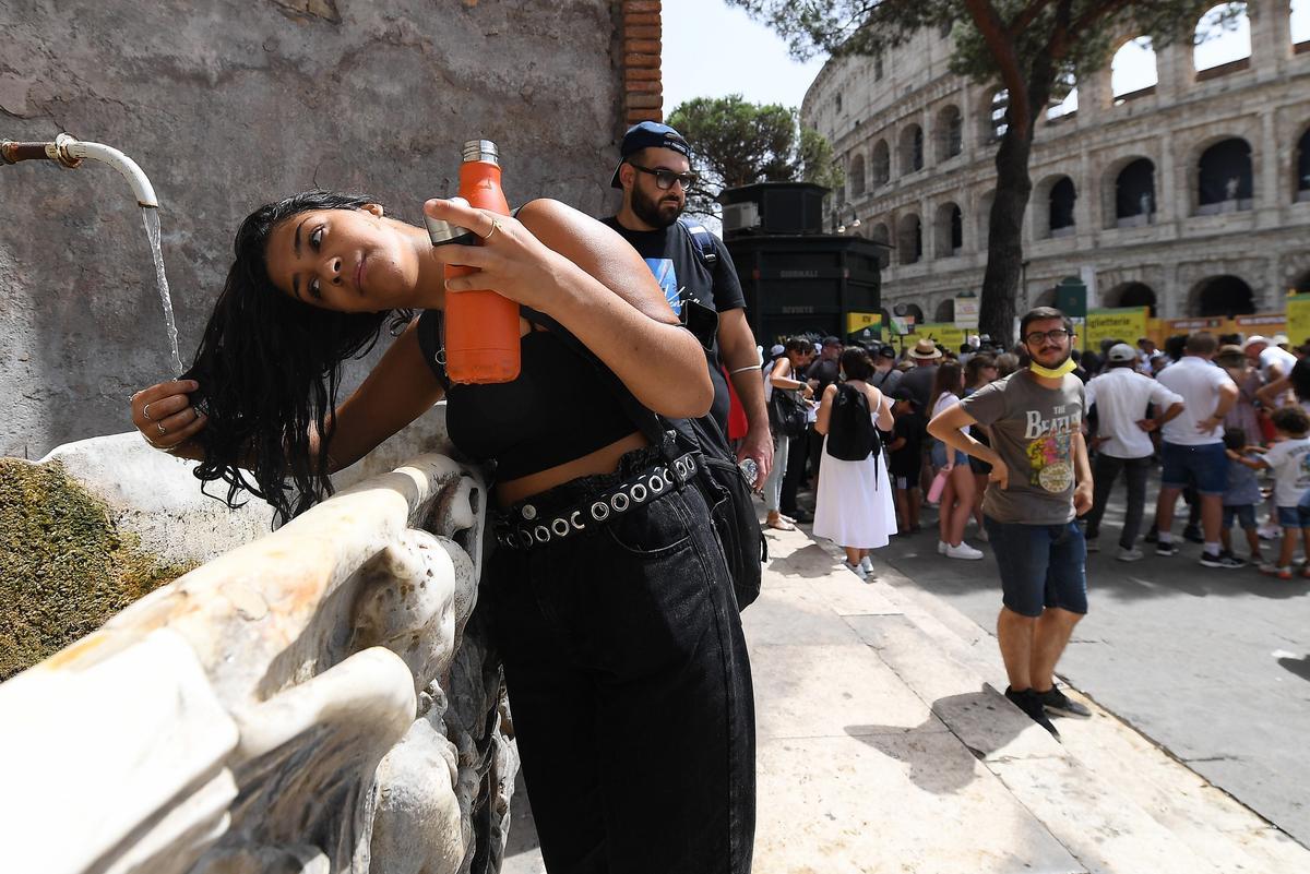 Una joven mojándose el pelo para refrescarse del calor en Italia.