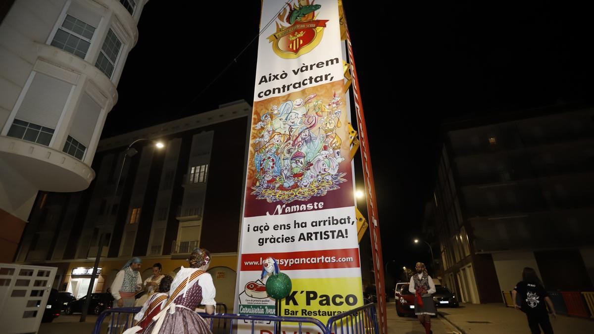 Una fallera de Passeig-Cardenal Serra, frente a la pancarta de denuncia emplazada ayer.