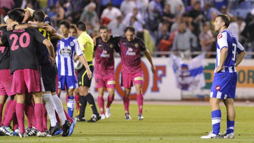 Varios jugadores del Hércules se abrazan al término del partido ante la mirada del delantero local Xisco.
