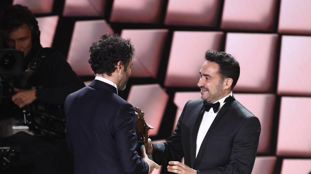 El director de cine Rodrigo Sorogoyen (i), recibe el Goya a mejor dirección por 'As bestas', de la mano del director de cine Juan Antonio Bayona (d), en la 37 edición de los Premios Goya.