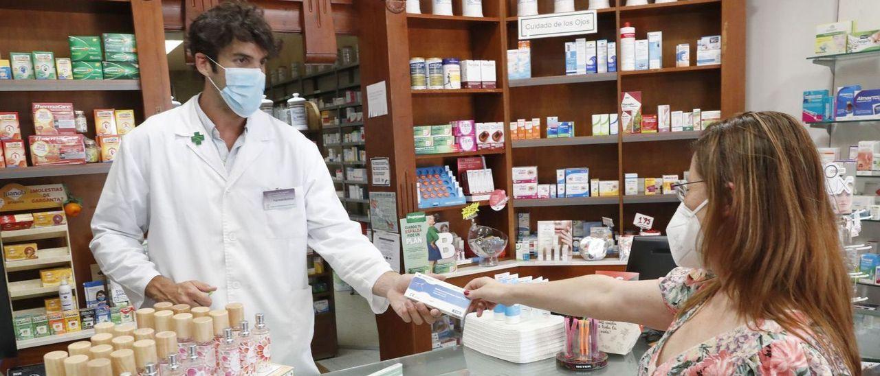 Una mujer compra un antígeno en una farmacia de Vigo.