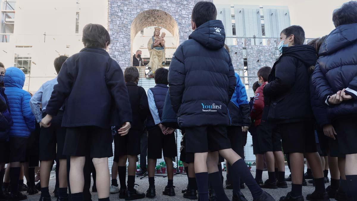 Un grupo de niños de una escuela de Madrid hacen una ofrenda floral a la Virgen de la Almudena