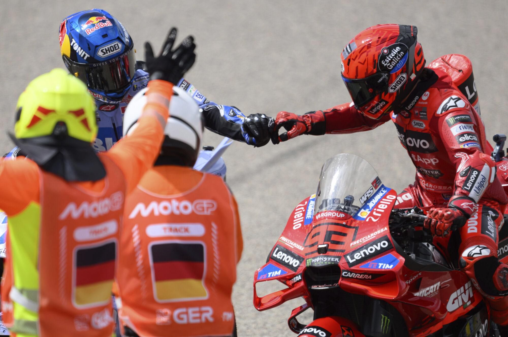 Winner Marc Marquez, right, from Spain from Team Ducati Lenovo and his brother Alex Marquez from Team Gresini Racing MotoGP (Ducati) bump fists following the MotoGP race, German Grand Prix, at the Sachsenring circuit, in Hohenstein-Ernstthal, Germany, Sunday July 13, 2025. (Robert Michael/dpa via AP). GERMANY OUT; MANDATORY CREDIT
