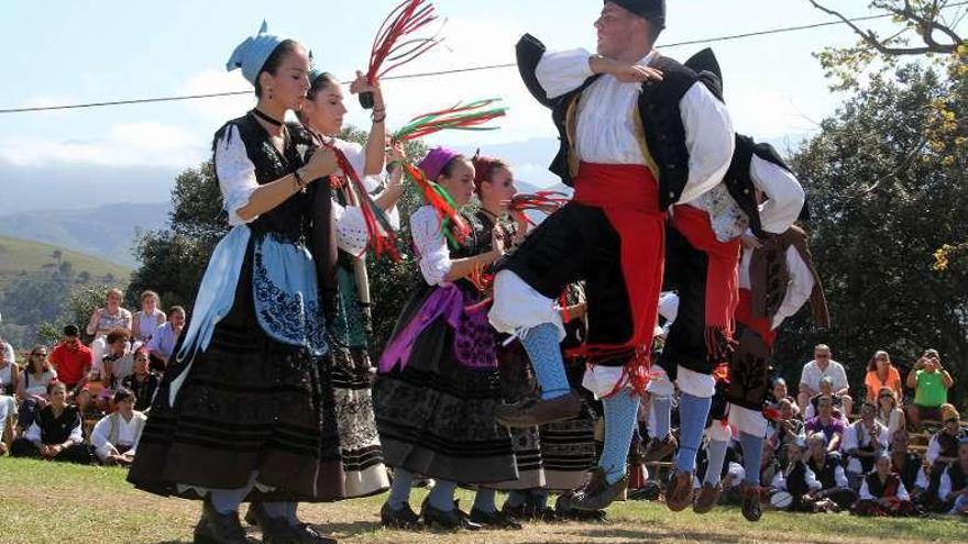 Jóvenes con los trajes de llanisca y porruanu bailan el pericote en la fiesta de la Guía.