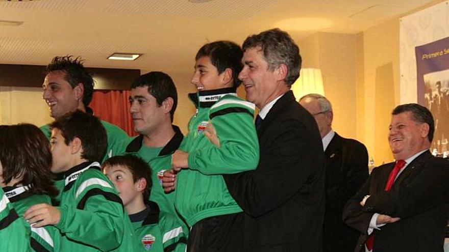 Ángel María Villar levanta a un niño para que salga en una foto durante el acto que presidió ayer en Alicante