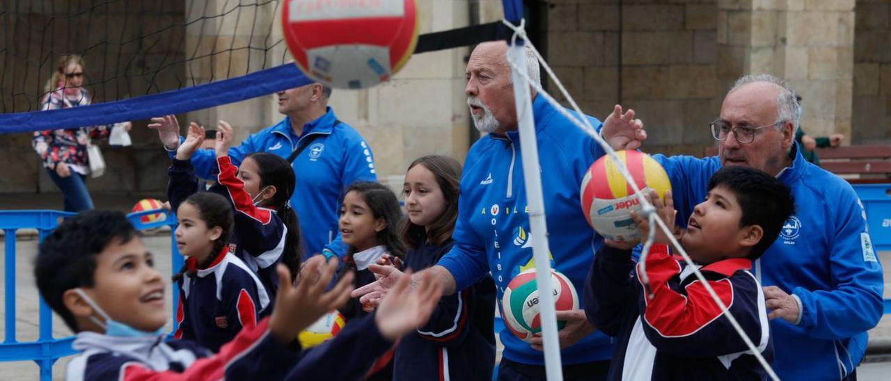 Los monitores del club A. D. La Curtidora explican a los niños del colegio San Nicolás las técnicas básicas para jugar al voleibol, ayer, en la plaza del Ayuntamiento. | Mara Villamuza