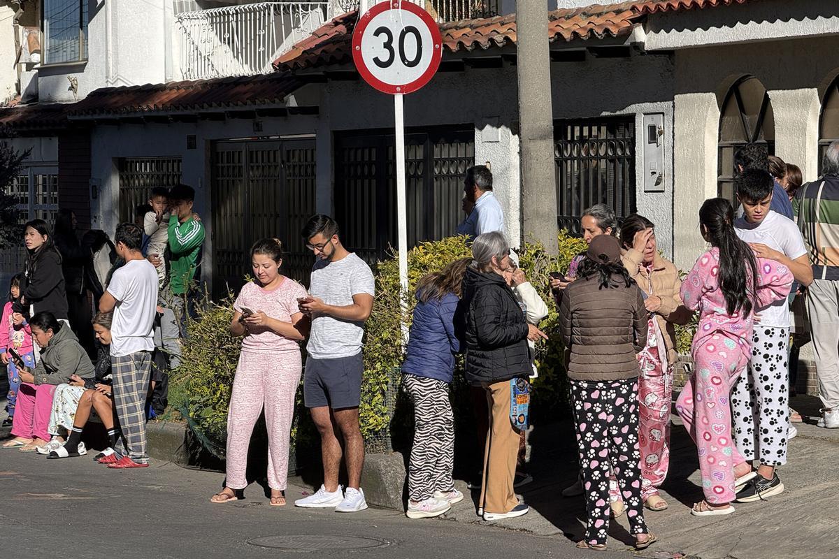 Personas evacuan edificios tras un fuerte temblor este lunes, en Bogotá (Colombia).
