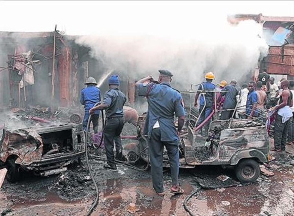 Bombers extingeixen el foc, després de l’atemptat doble a Jos, ahir.