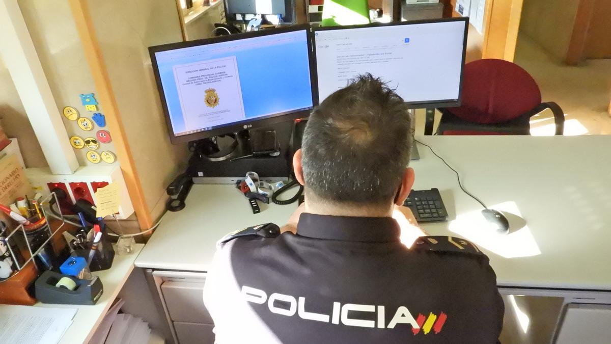 Un agente de Policía Nacional, delante de un ordenador.
