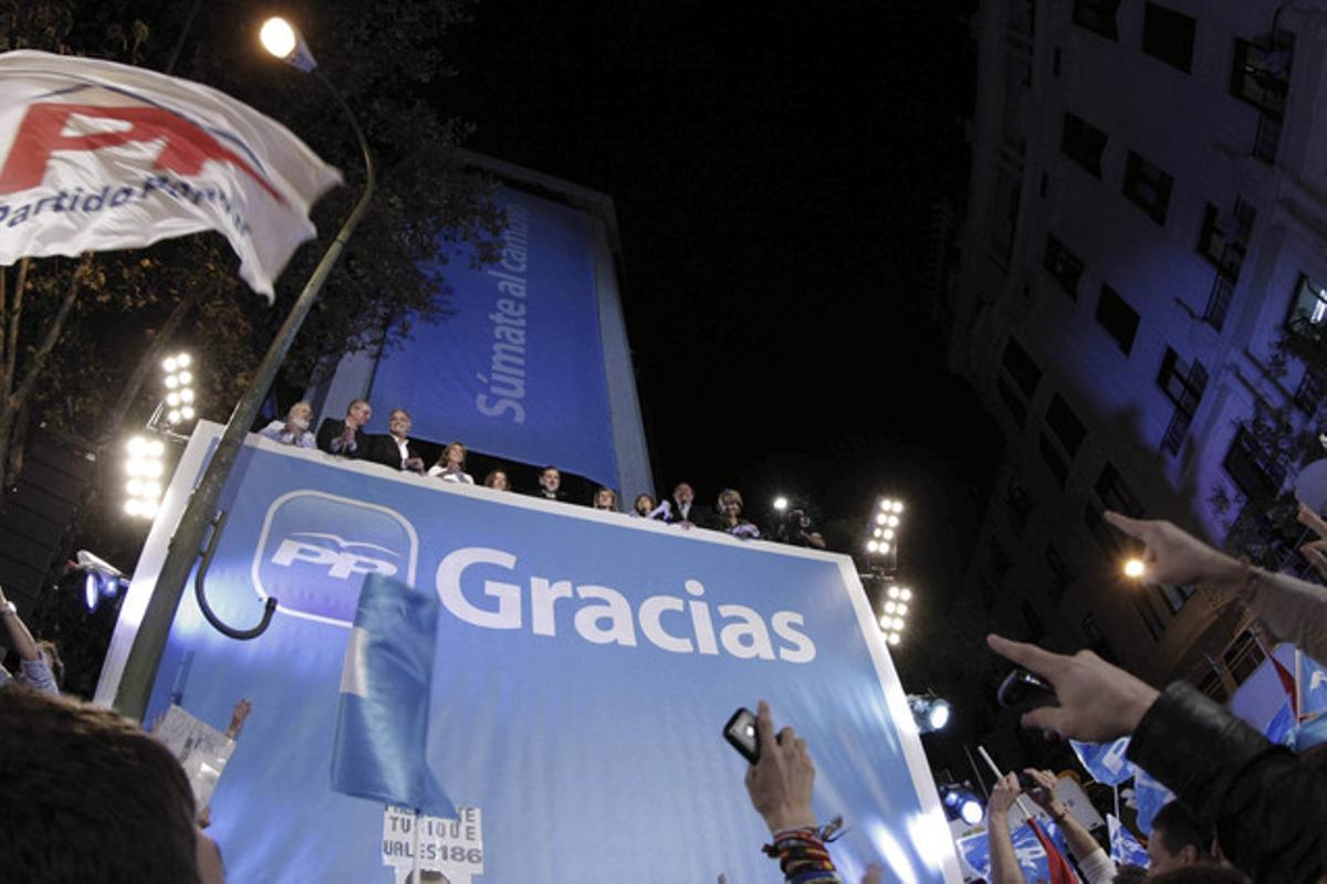 Centenars de simpatitzants del PP celebren la victòria de Rajoy davant la seu del PP, ahir a la nit a Madrid.