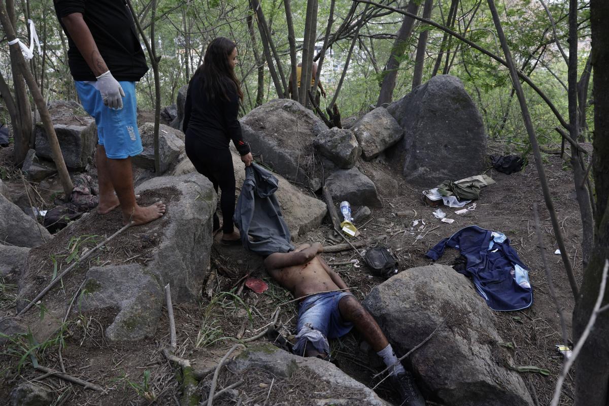ATENCIÓN EDITORES: CONTENIDO GRÁFICO EXPLICITO ACOMPAÑA CRÓNICA: BRASIL DROGAS AME3085. RÍO DE JANEIRO (BRASIL), 29/10/2025.- Personas retiran un cuerpo sin vida de una zona boscosa este miércoles, en la favela Vila Cruzeiro en Río de Janeiro (Brasil). El megaoperativo del martes, en el que participaron 2.500 agentes, tenía como objetivo detener a cabecillas del Comando Vermelho, una de las organizaciones criminales mas antiguas y peligrosas de Rio. EFE/ André Coelho ATENCIÓN EDITORES: CONTENIDO GÁFICO EXPLICITO. ATENCIÓN EDITORES: CONTENIDO GÁFICO EXPLICITO ACOMPAÑA CRÓNICA: BRASIL DROGAS