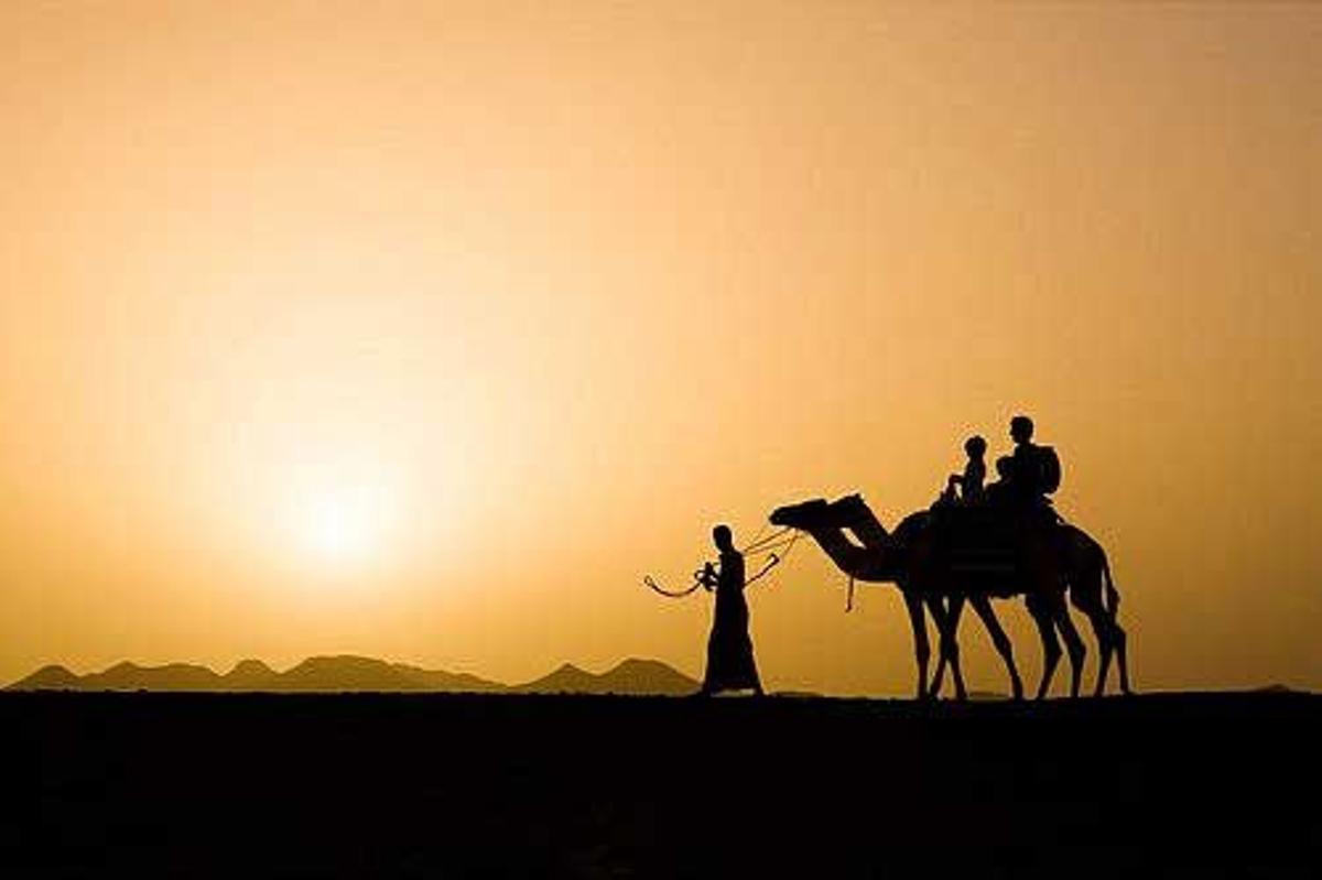 Turistas en camello en llevados por un beduino en Marse Alam, al sur de Hurgada.