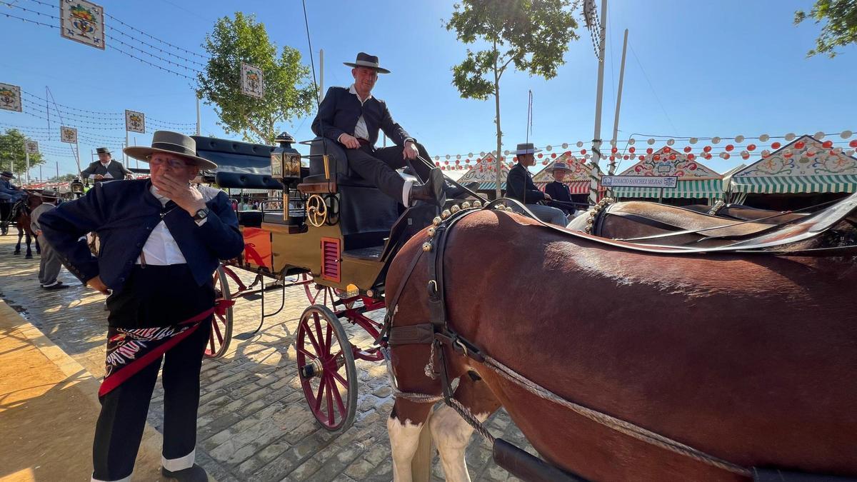 Juan Oliva, en el Real de la Feria de Sevilla, junto a su coche de caballos