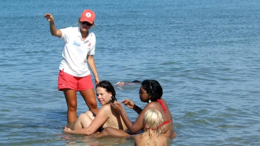 Una socorrista de las playas de Dénia hace indicaciones a los bañistas