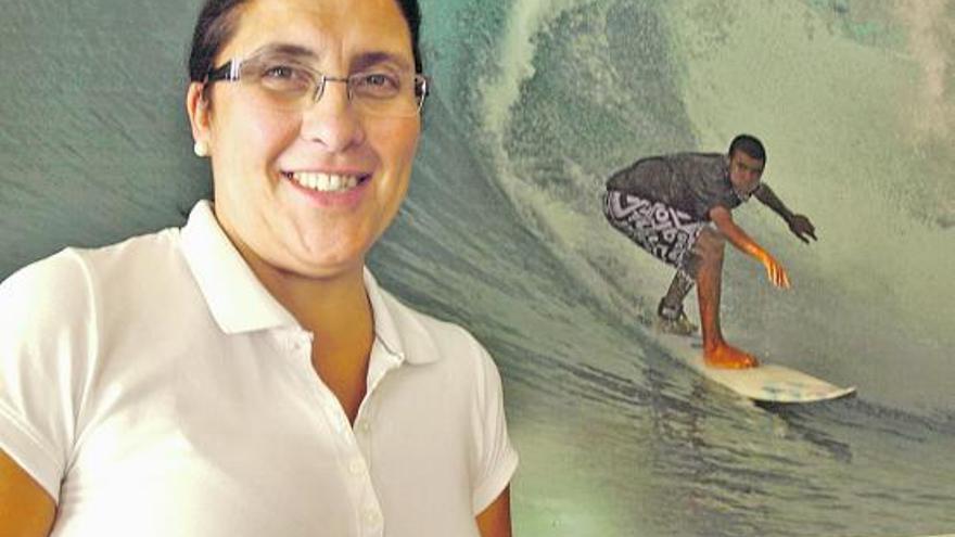 Ludivina Barrigón García posa junto a una foto de su hijo, experto surfista, en el interior del bar Ludi. | ana paz paredes