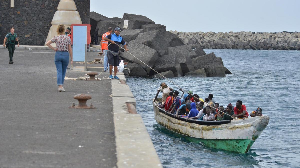 Varias personas llegan en un cayuco al muelle de La Restinga, en la isla de El Hierro