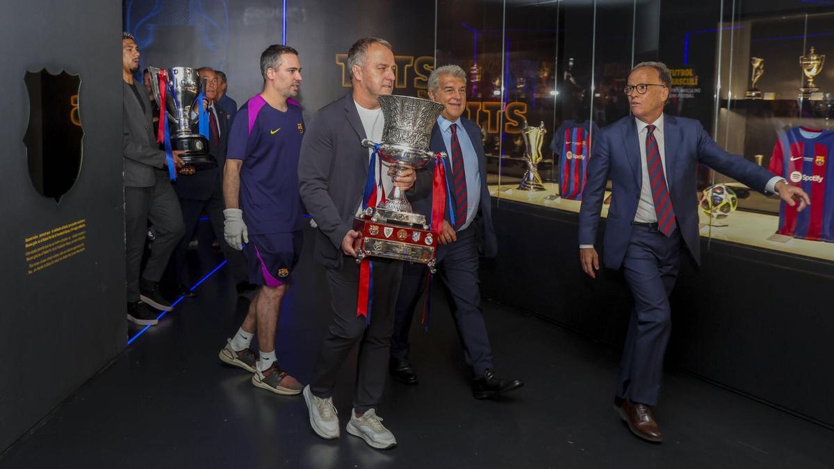 Hansi Flick porta el trofeu de la Lliga al Museu del Barça, al costat de Laporta.