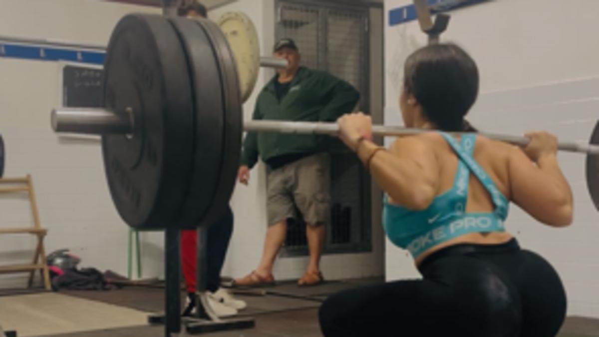 Una de las levantadoras del CH Tavernes, en un entrenamiento en presencia del presidente de la entidad