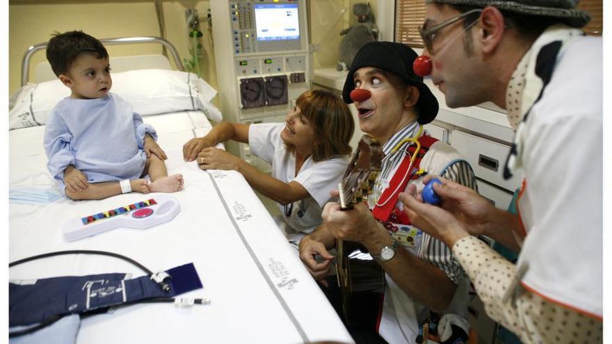 Miembros de PayaSOSpital junto a un niño ingresado en un hospital.